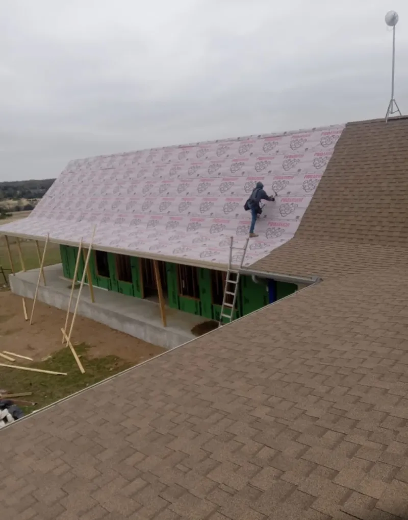 Worker preparing underlayment for a metal roof installation in Greenbrier
